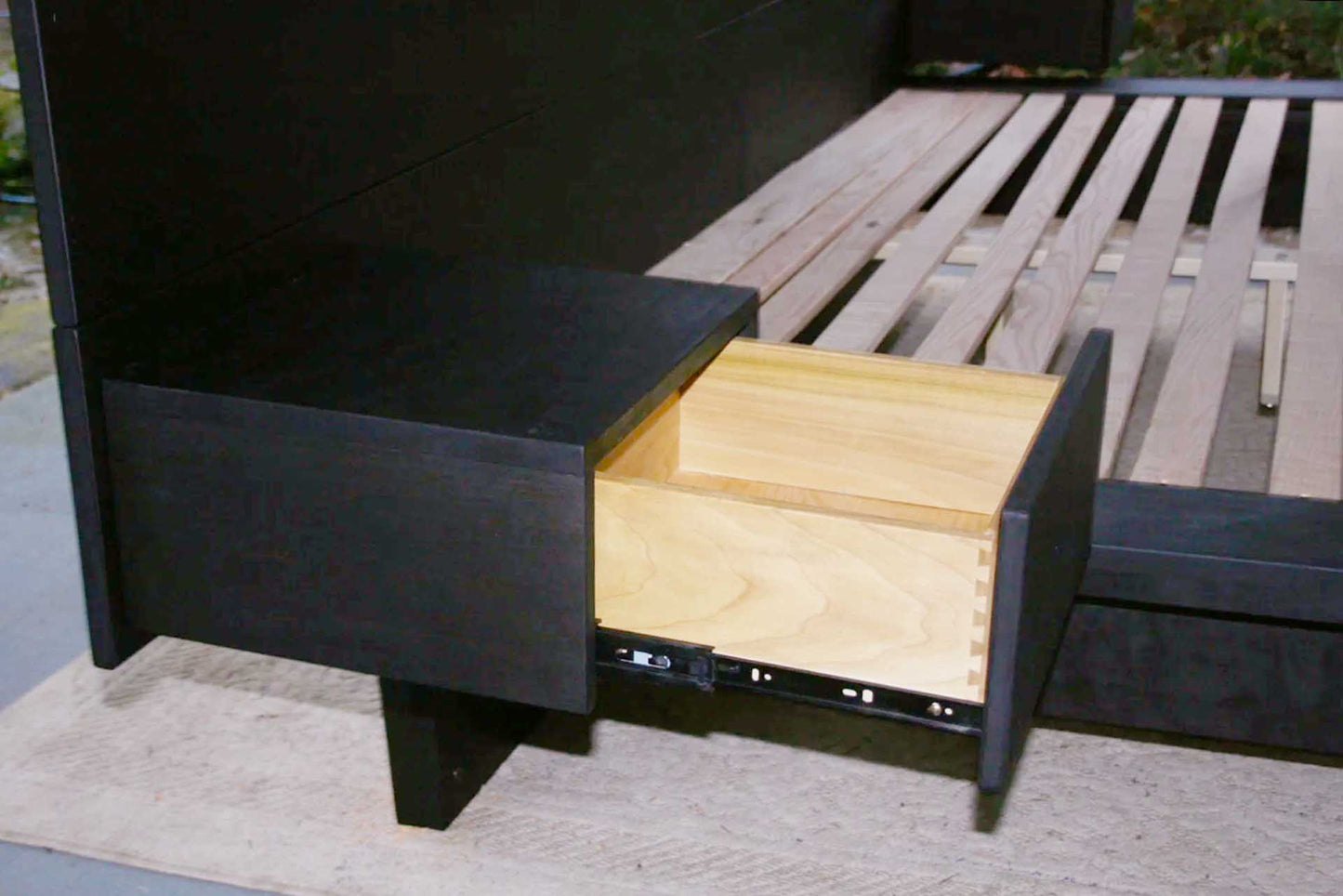 Low Platform side Table with one Drawer open on bed