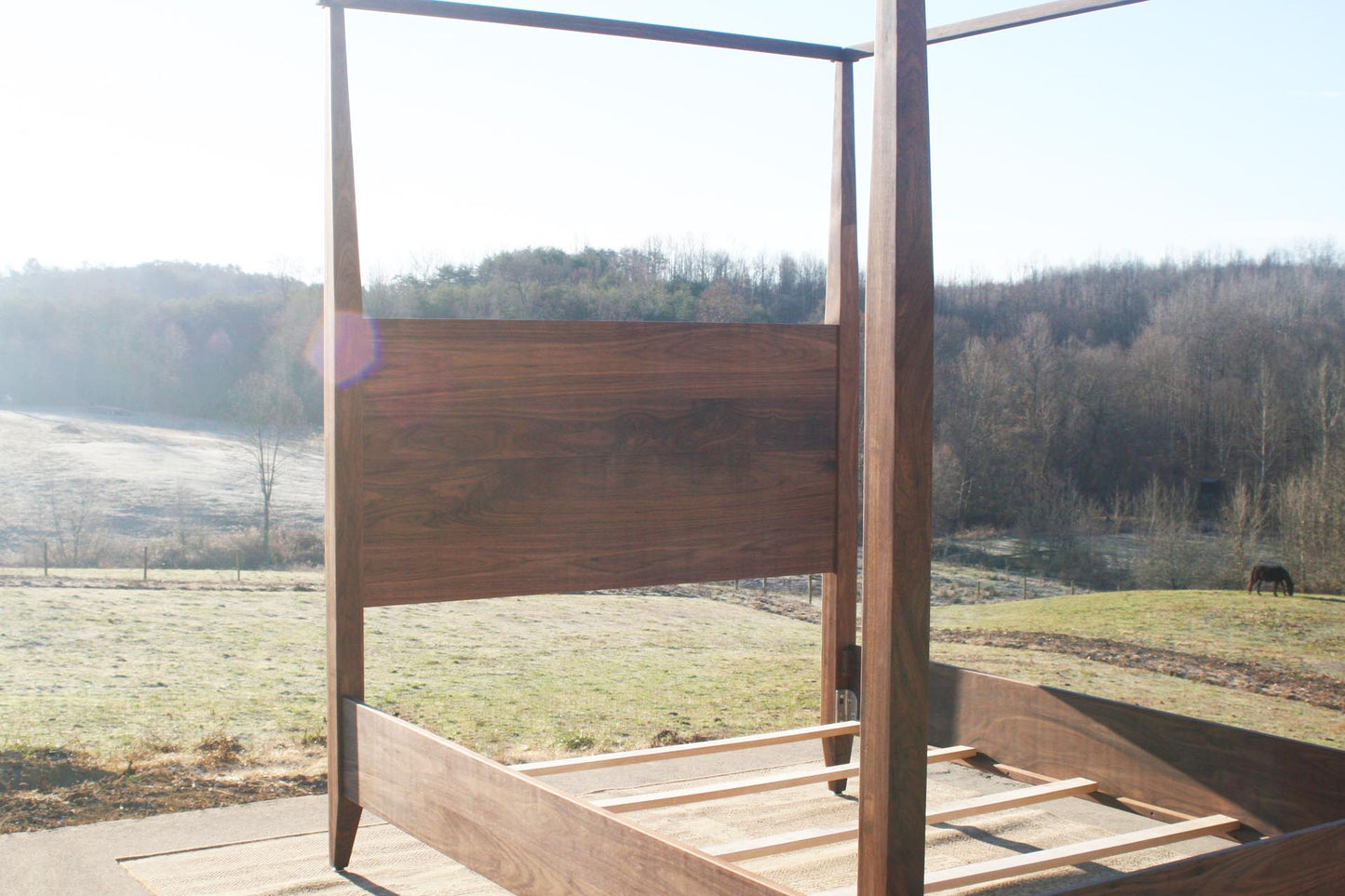 walnut wood canopy bed with tapered posts and headboard close view