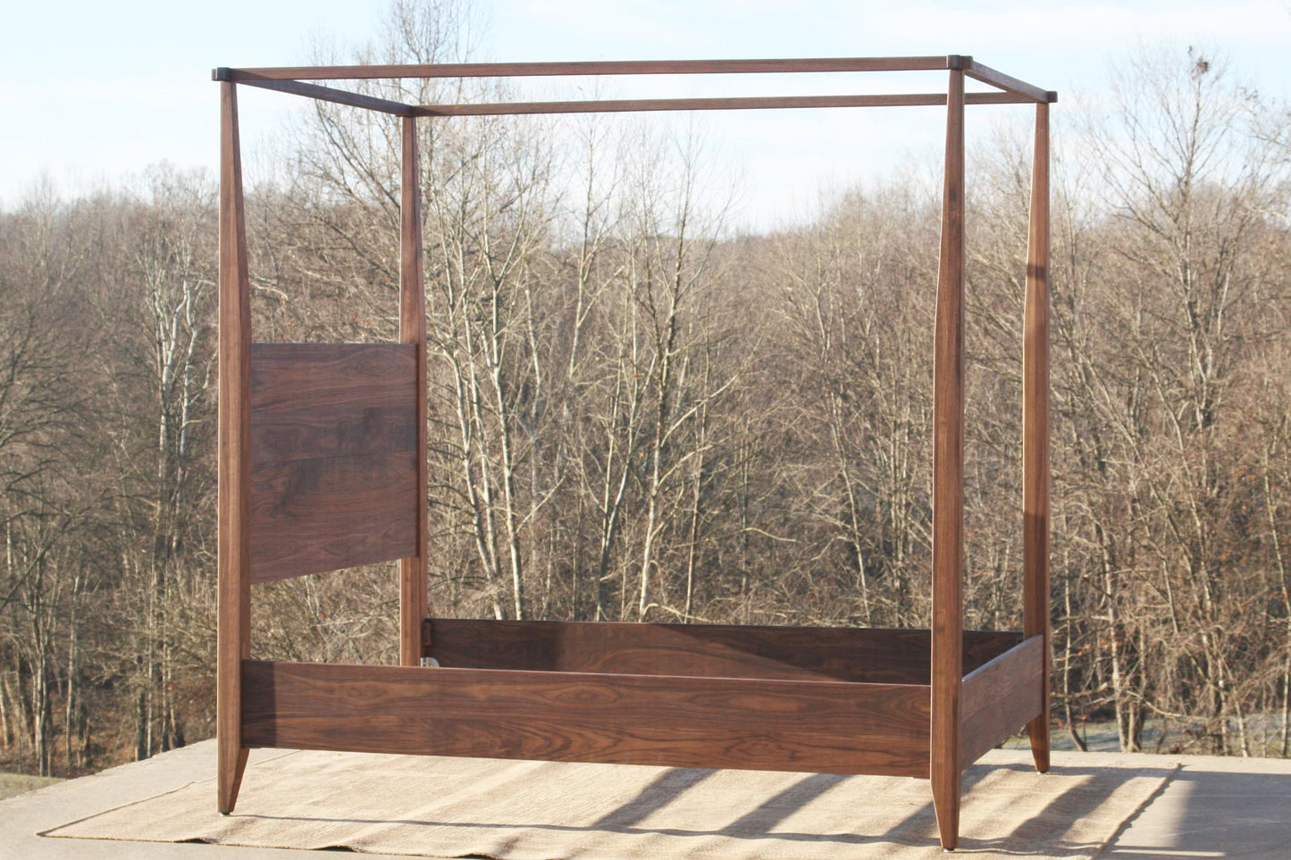 side view walnut wood canopy bed with tapered posts and headboard