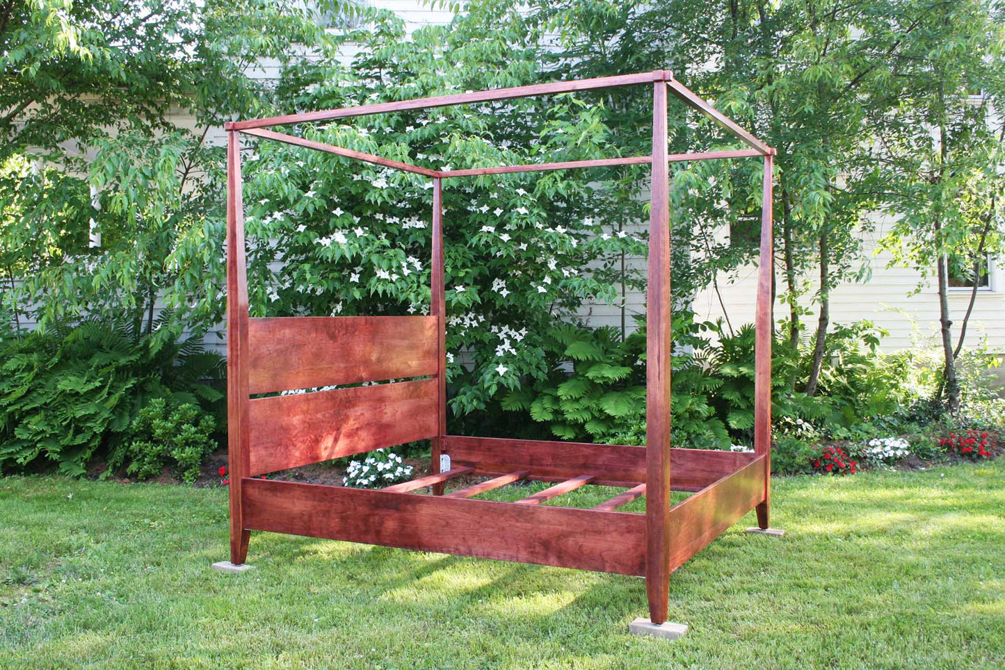 Solid wood canopy bed with tapered posts and headboard