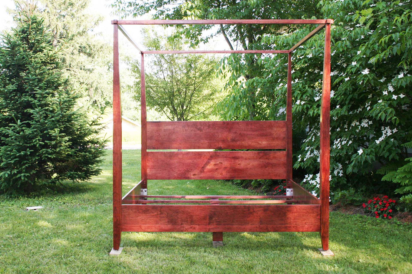 Solid wood canopy bed with tapered posts and headboard front view