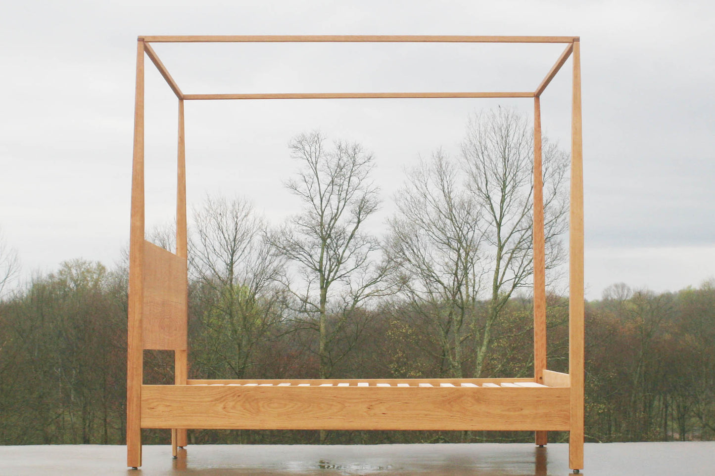 Canopy bed with tapered posts and headboard side view