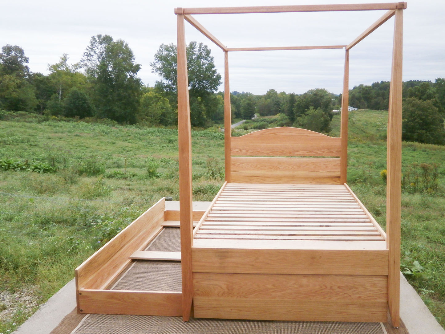 front view Canopy bed with trundle and arched headboard and trundle bed open