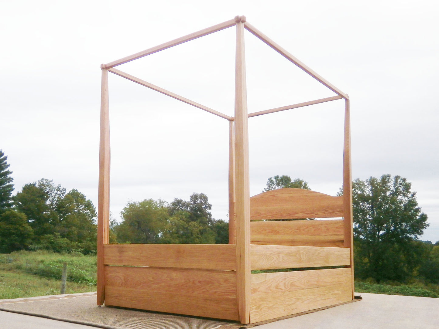 angled view Canopy bed with trundle and arched headboard