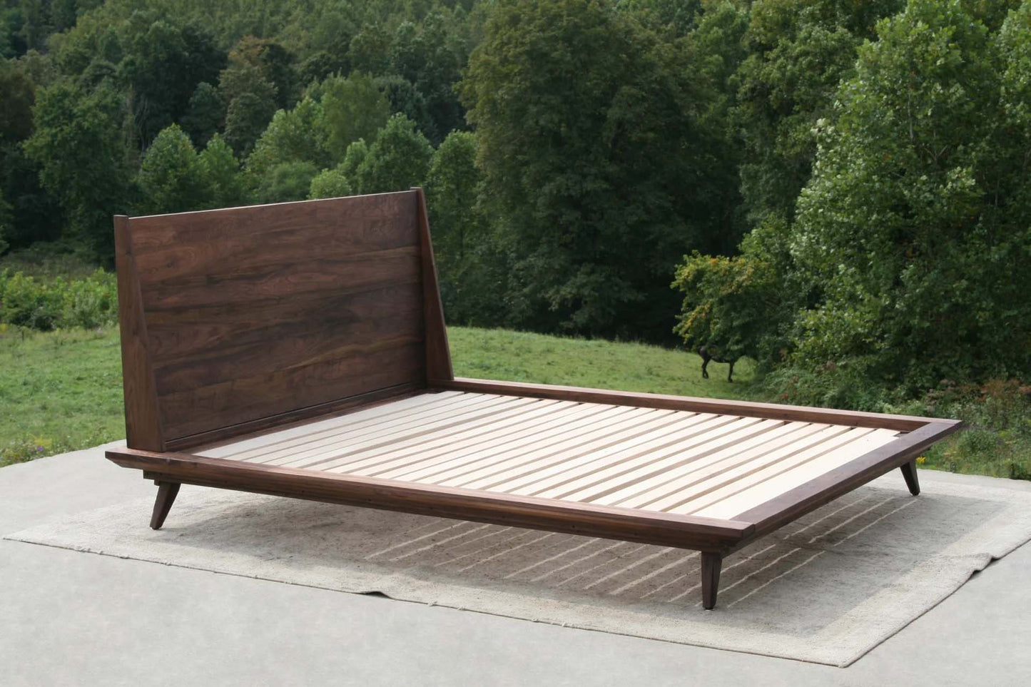 angled view modern platform bed in walnut wood