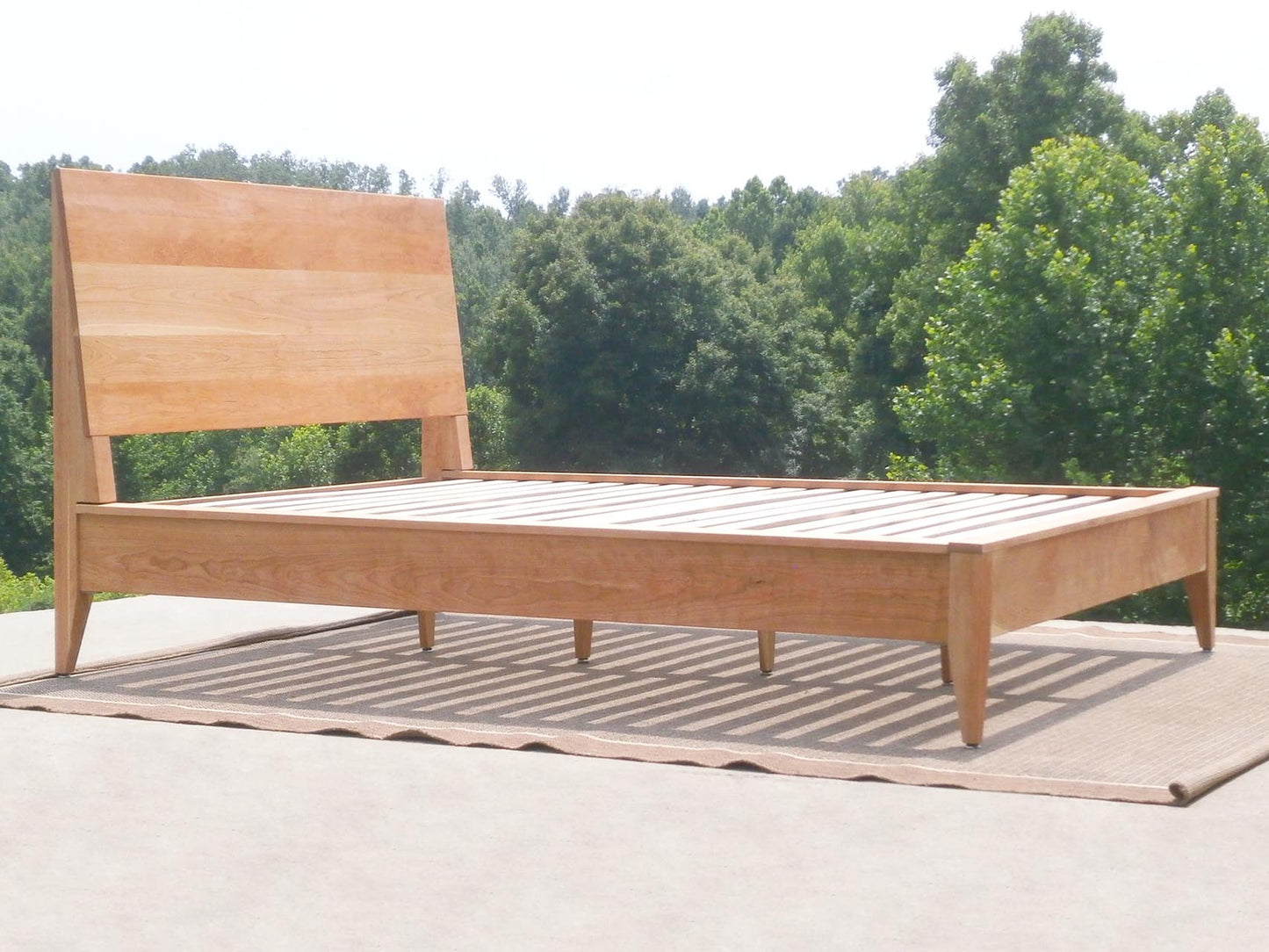 angled view natural wood platform bed