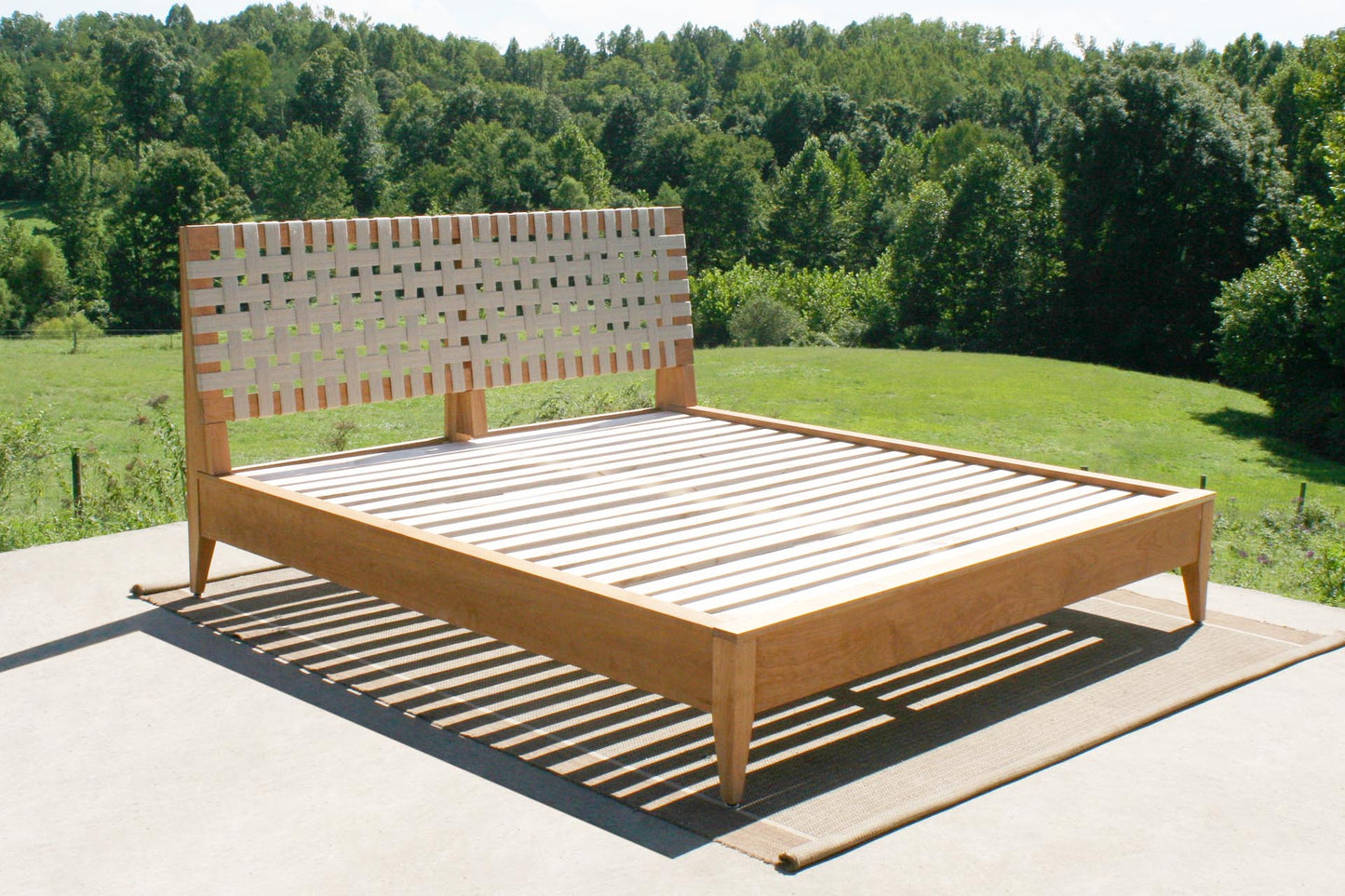 angled view of Platform bed with organic fabric headboard in solid hardwood