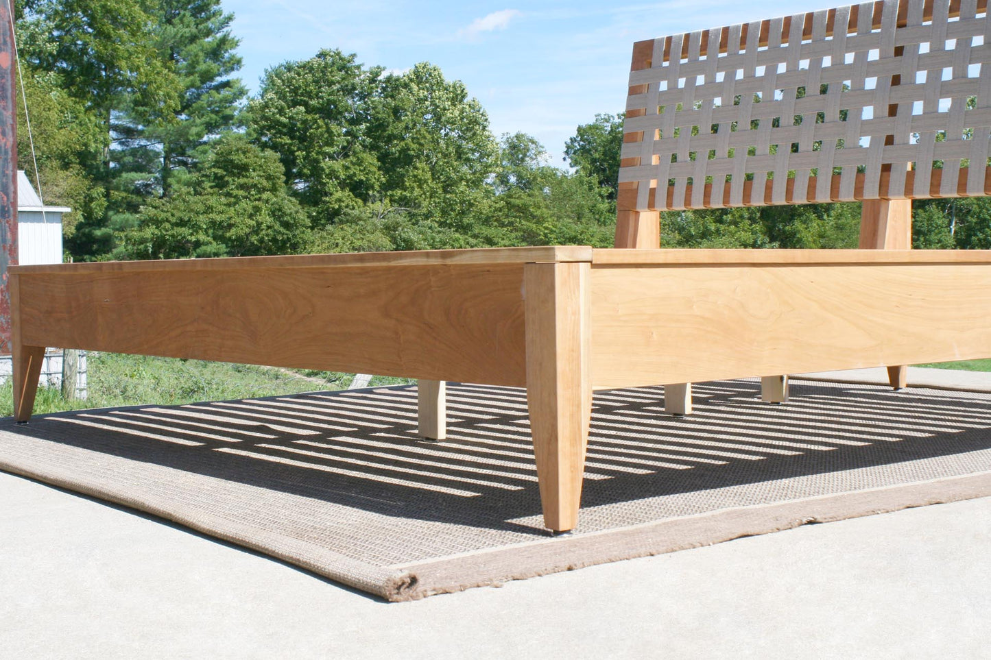 corner of solid custom platform bed with fabric headboard