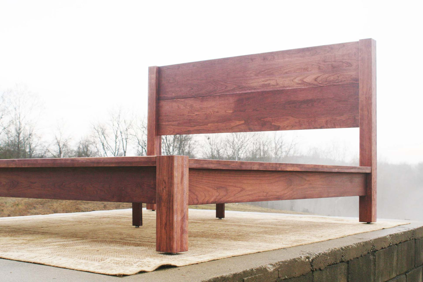 low angled view platform bed with thick posts and vertical headboard