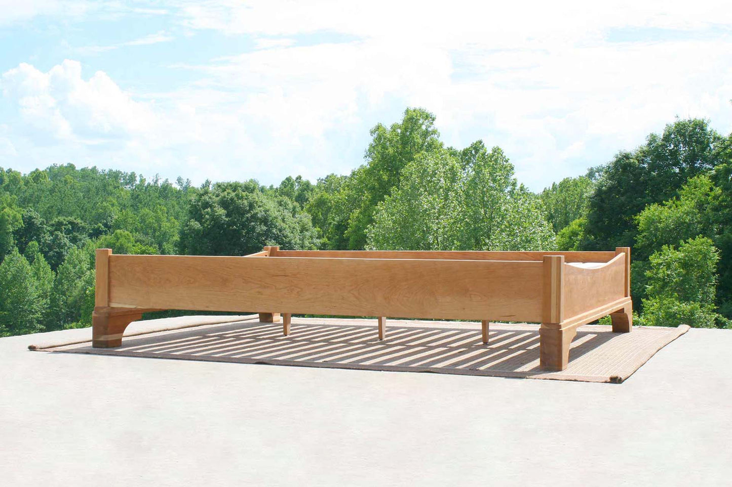 side angle view of Platform Bed with large block feet and arched ends
