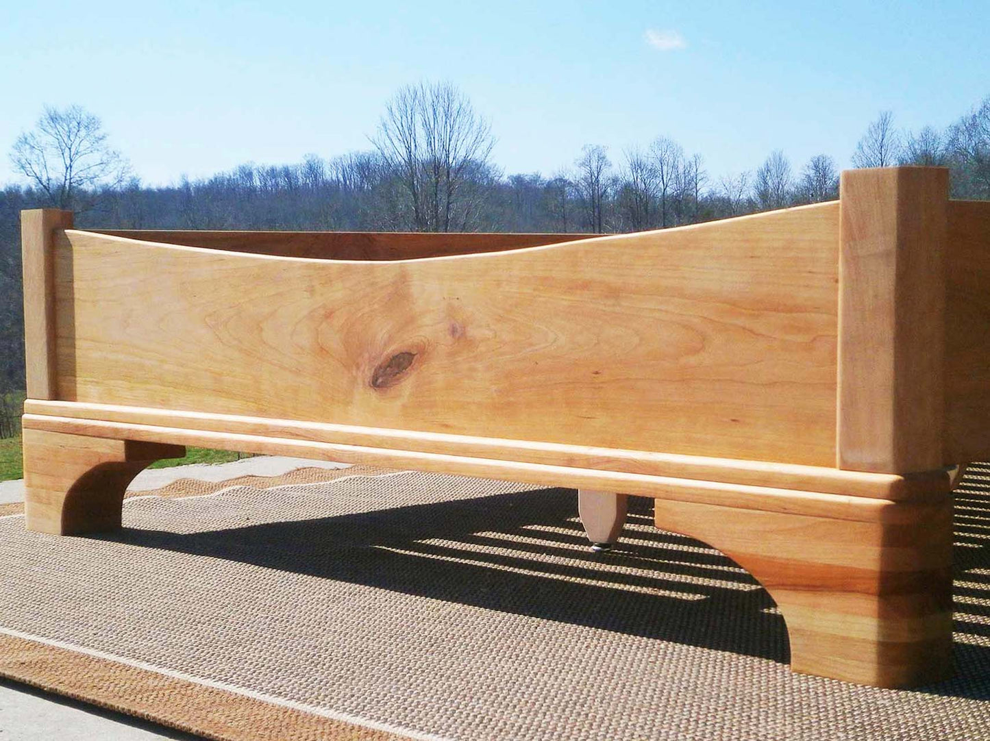 Platform Bed with large block feet and arched ends low angled view natural