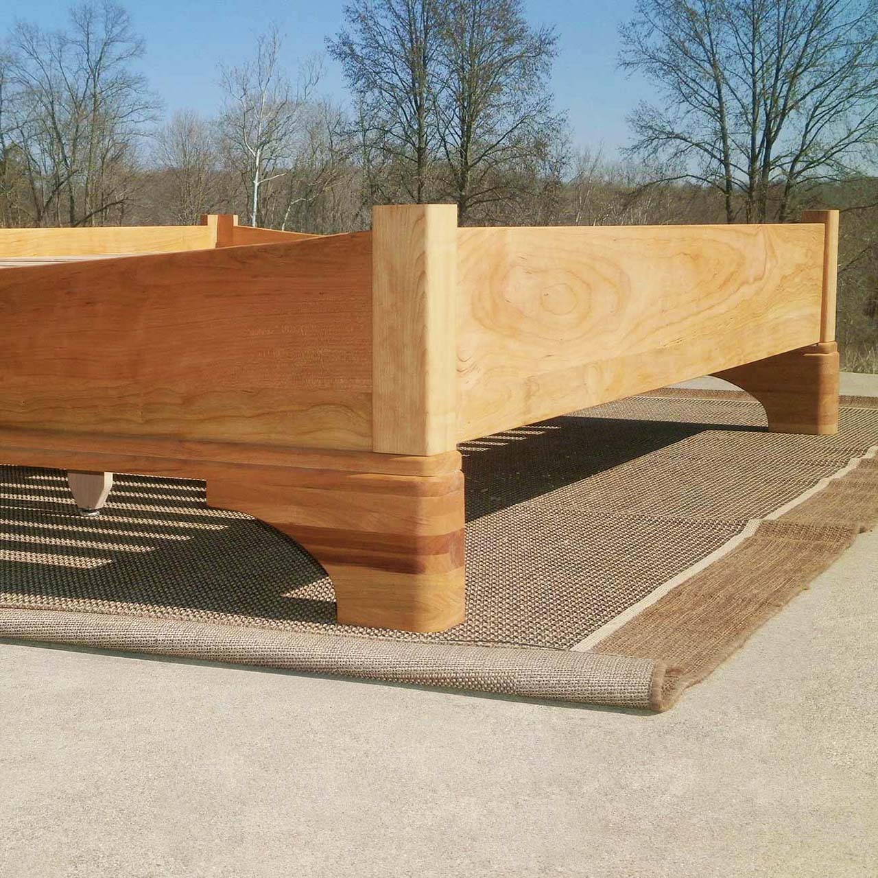 end of Platform Bed with large block feet and arched ends low angled view