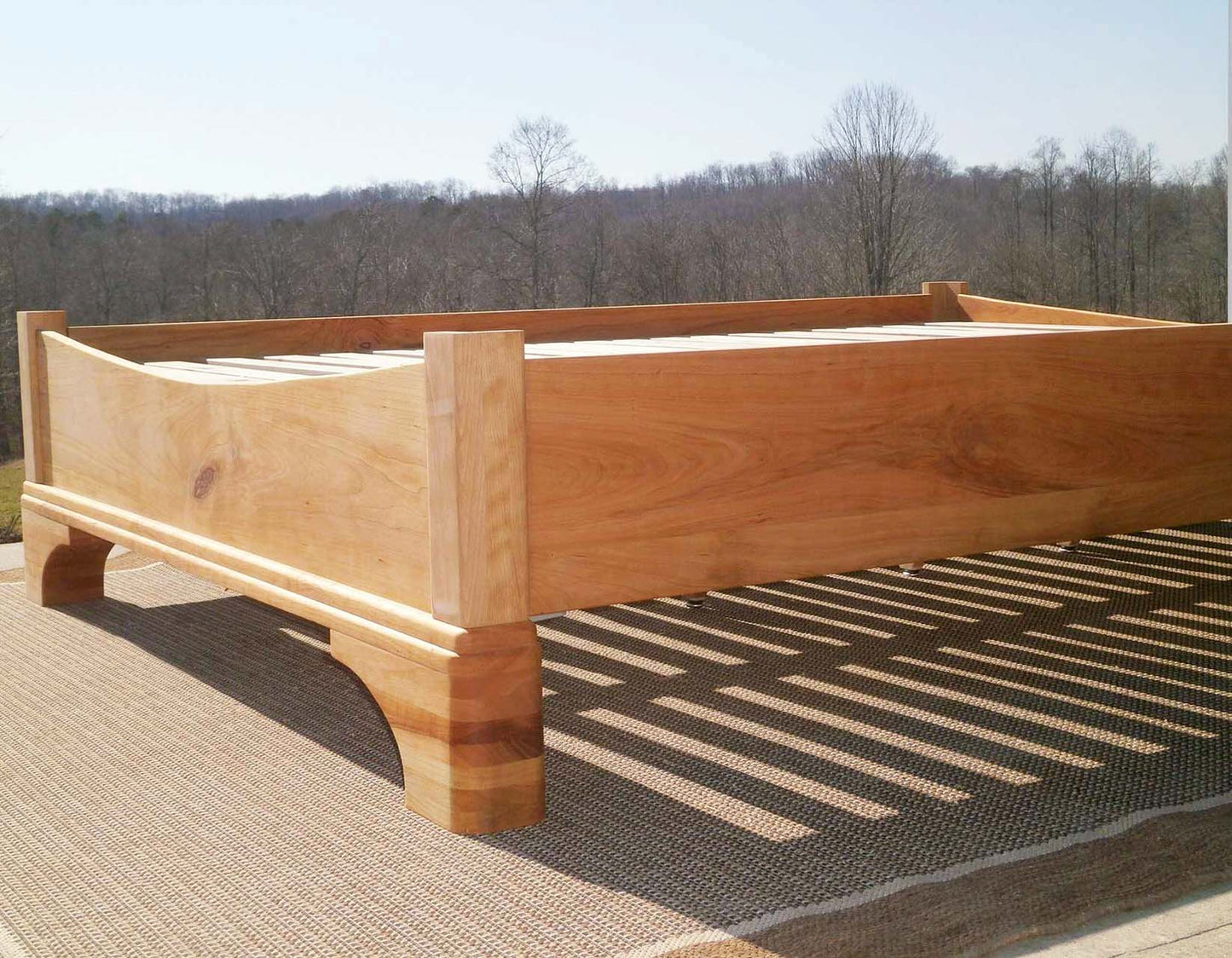 Platform Bed with large block feet and arched ends low angled view
