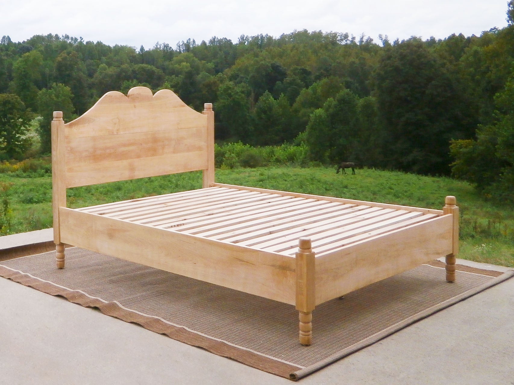 Classic four poster bed with turned posts and scrolled headboard