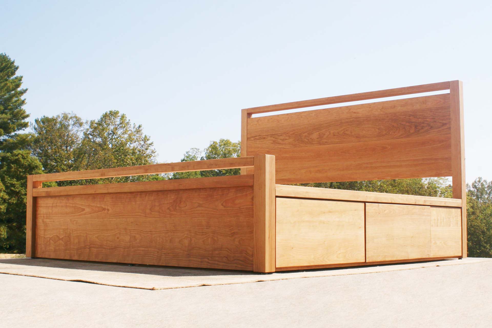 low angled view natural Platform Bed with 4 drawers, thick headboard and footboard and square posts