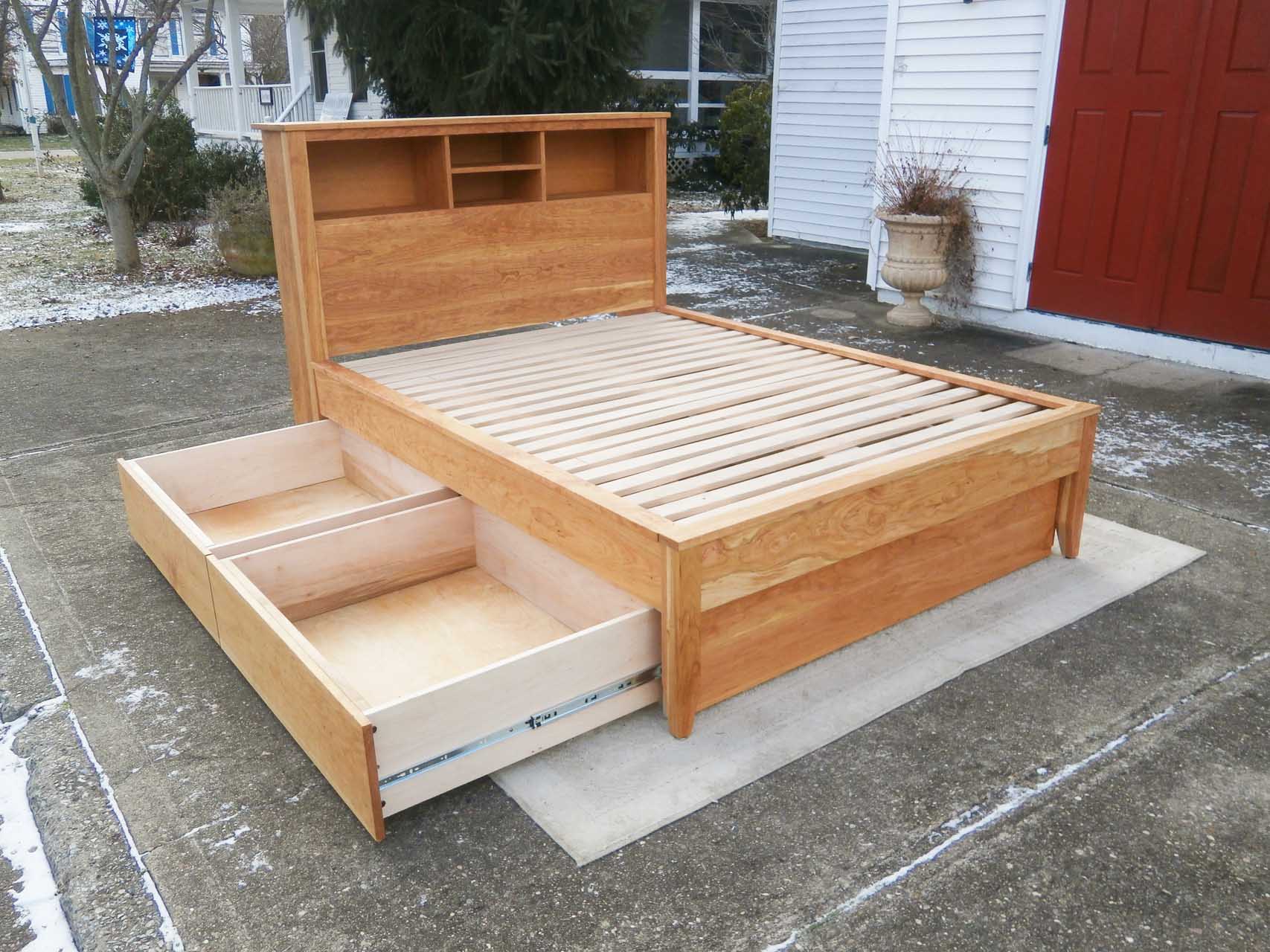 angled view platform bed with bookcase headboard and 4 drawers drawers out