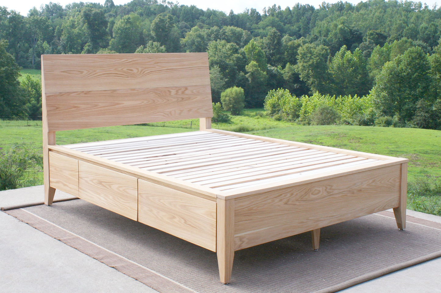 angled view natural hardwood Platform storage bed with headboard