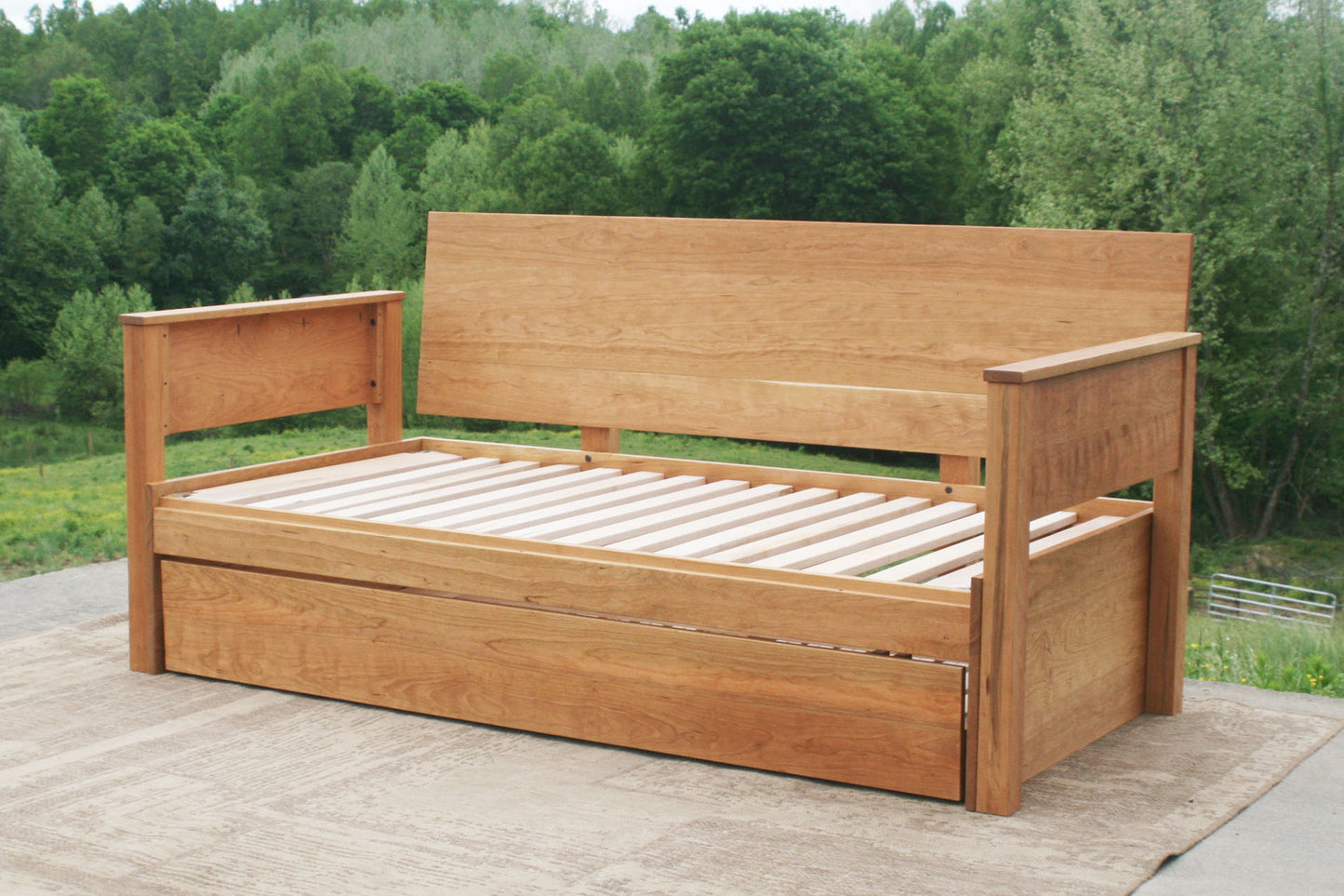 Daybed with trundle, backboard and armrests angled view