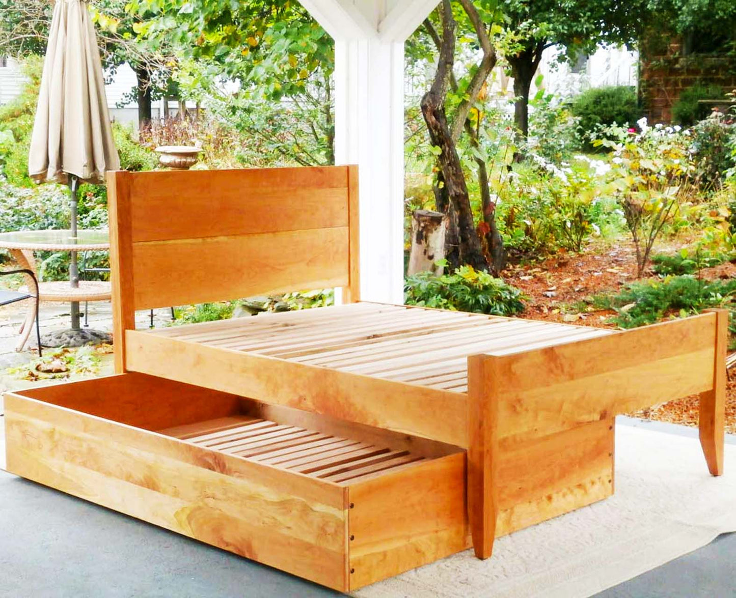 angled view Trundle Bed with headboard and footboard trundle half pulled out hardwood