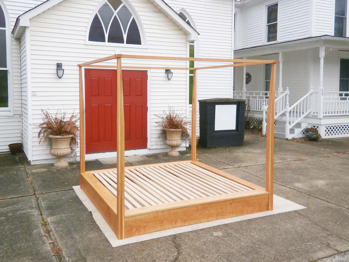 side angled view canopy bed with low platform large rail canopy and tapered posts