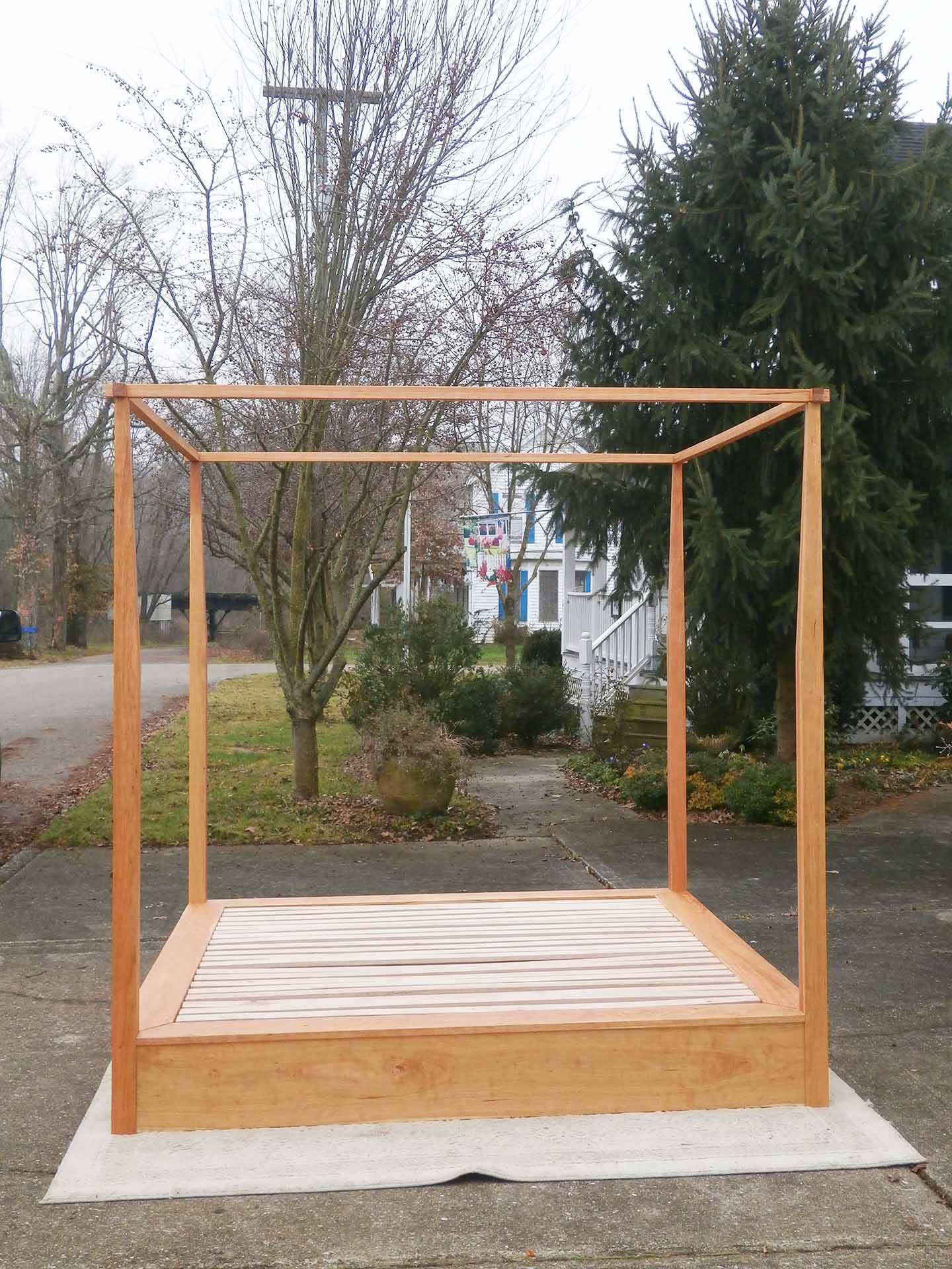 front view natural canopy bed with low platform large rail canopy and tapered posts