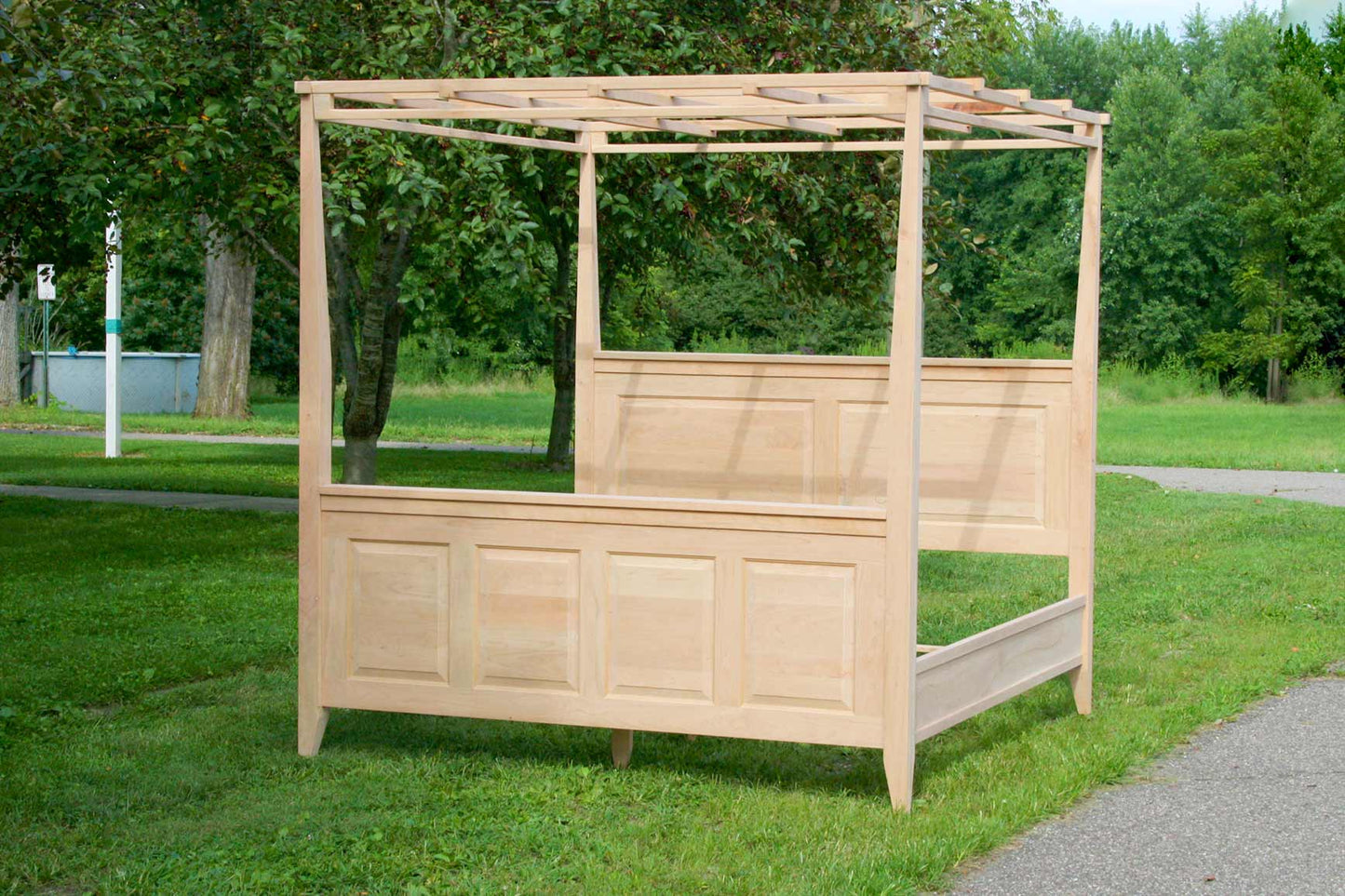 front angled view canopy bed with paneled head and footboard tapered posts box spring base options for top rails and finials