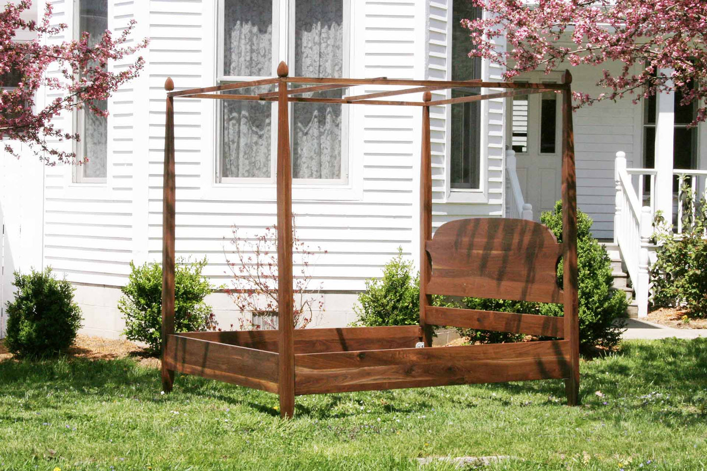 angled view canopy bed with tapered posts and curved headboard