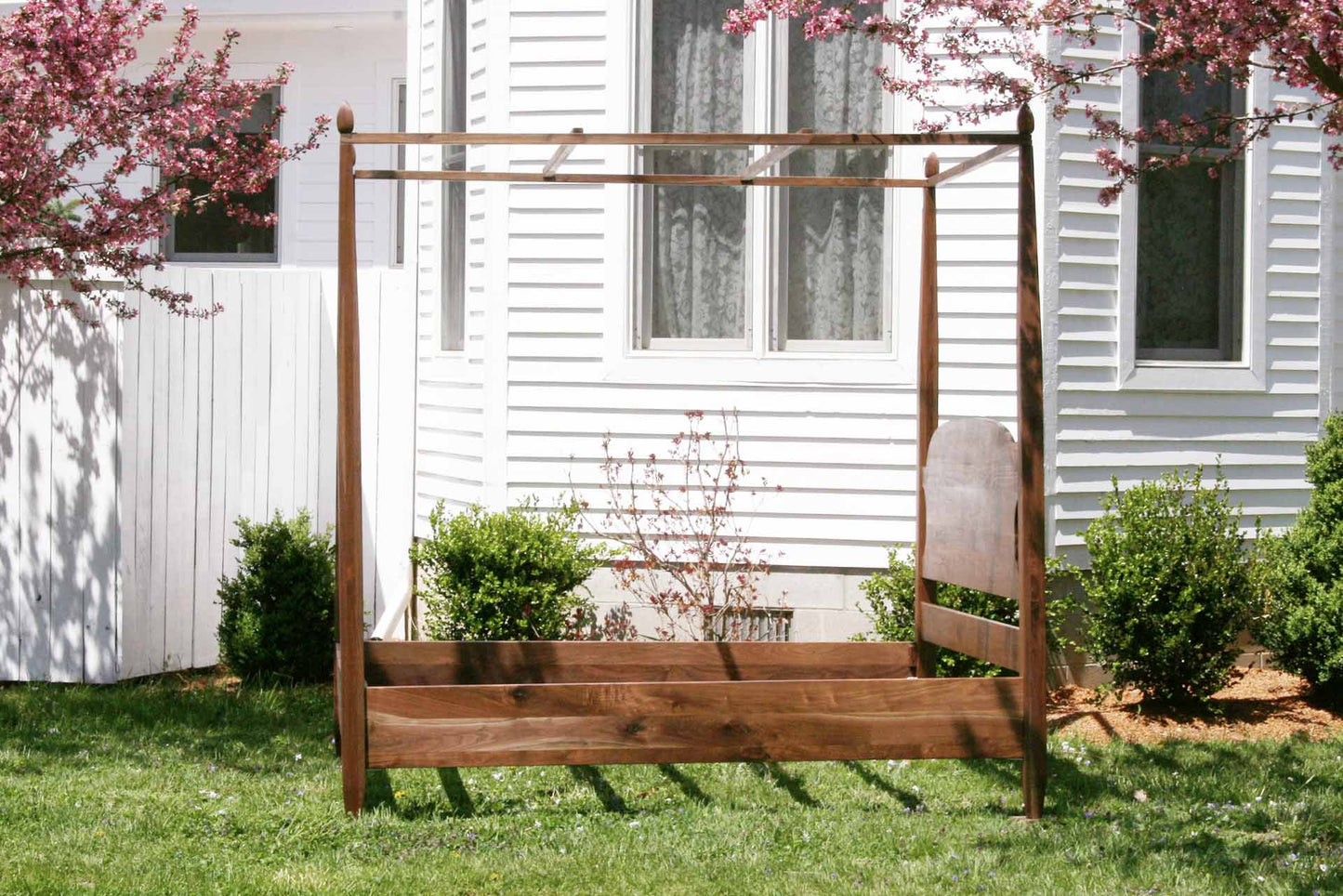 side view canopy bed with tapered posts and curved headboard