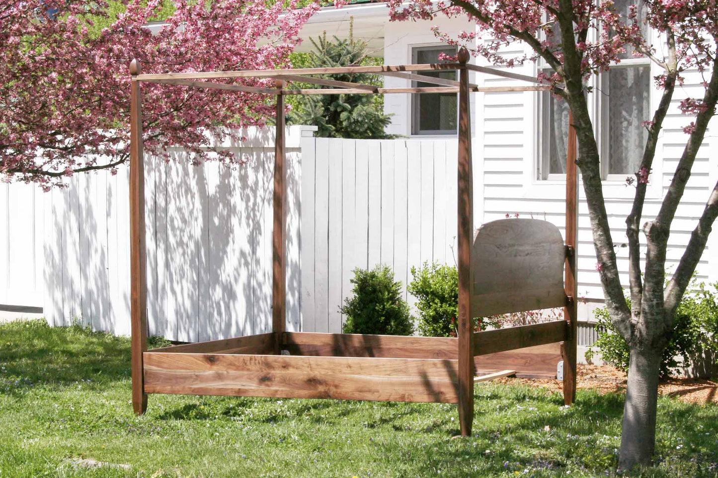 back angled view canopy bed with tapered posts and curved headboard