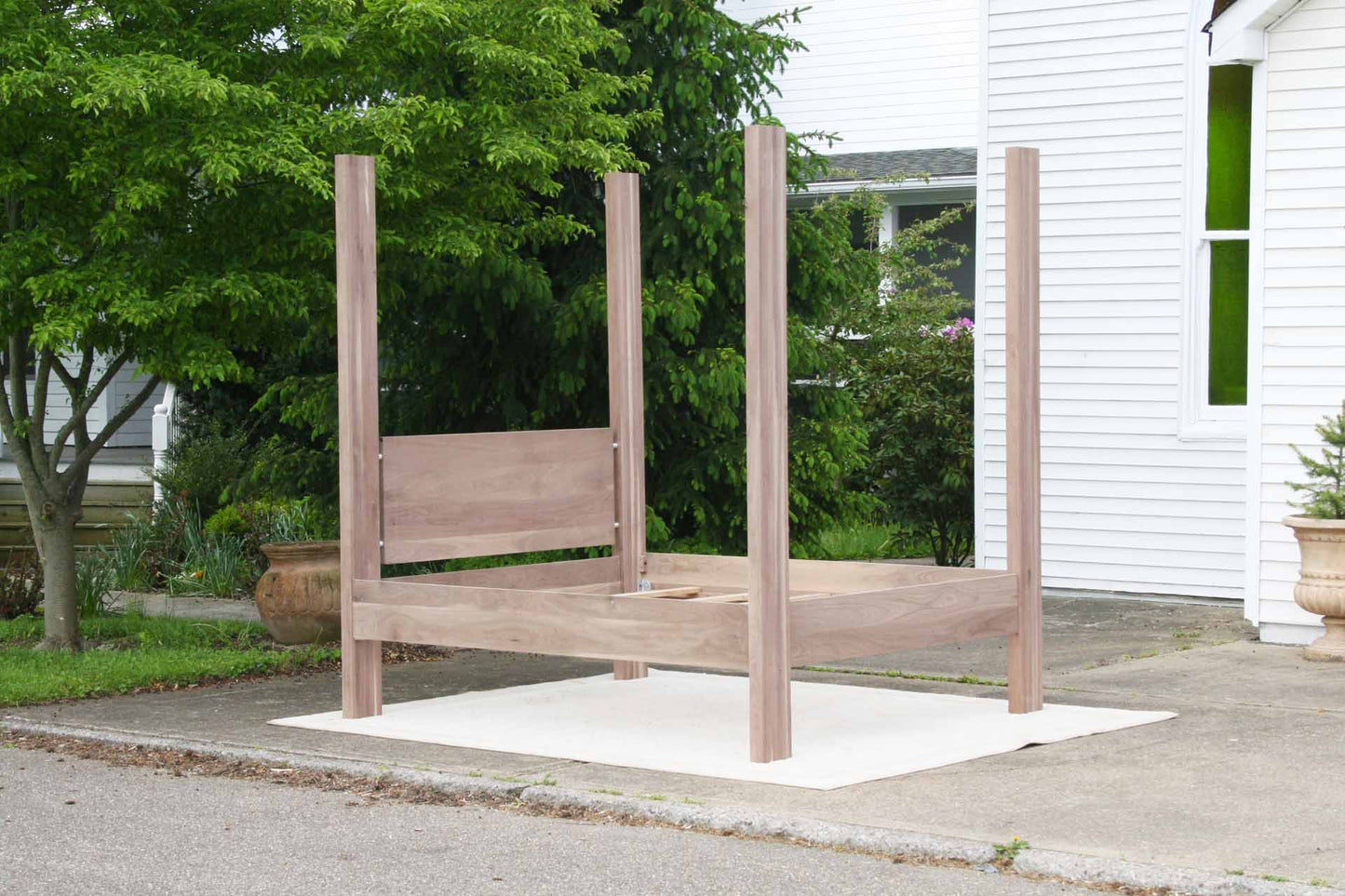 four poster bed with large straight posts and headboard angled view