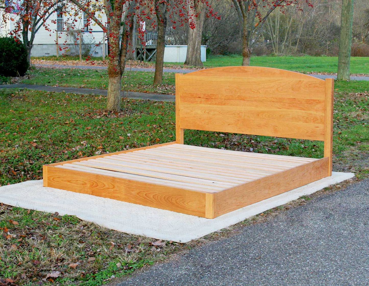 low platform bed with arched headboard angled view