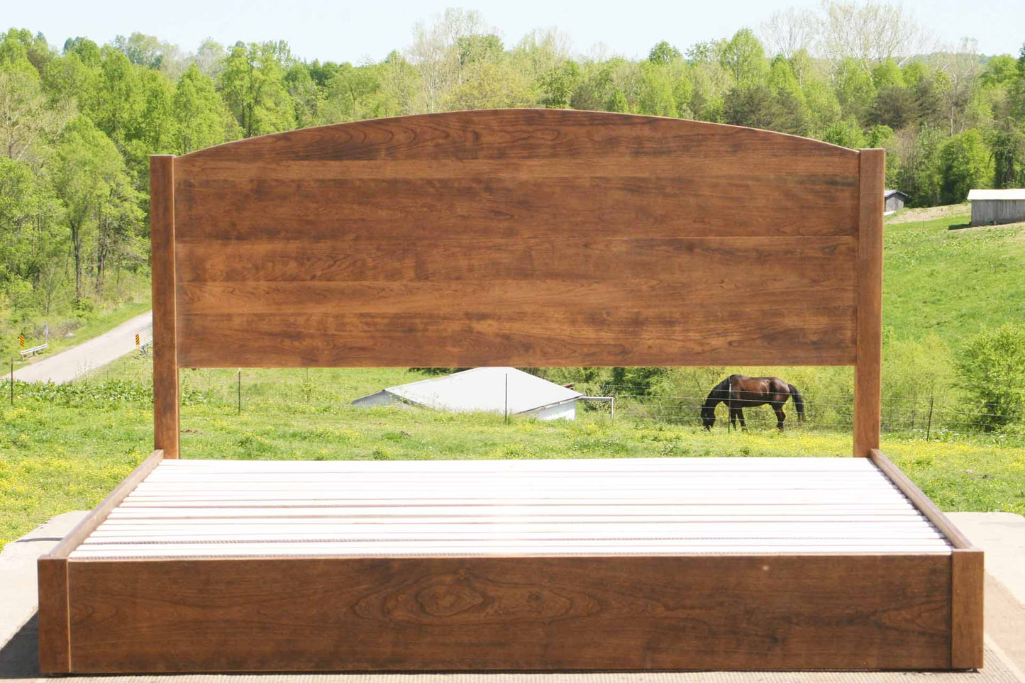 low platform bed with arched headboard front view