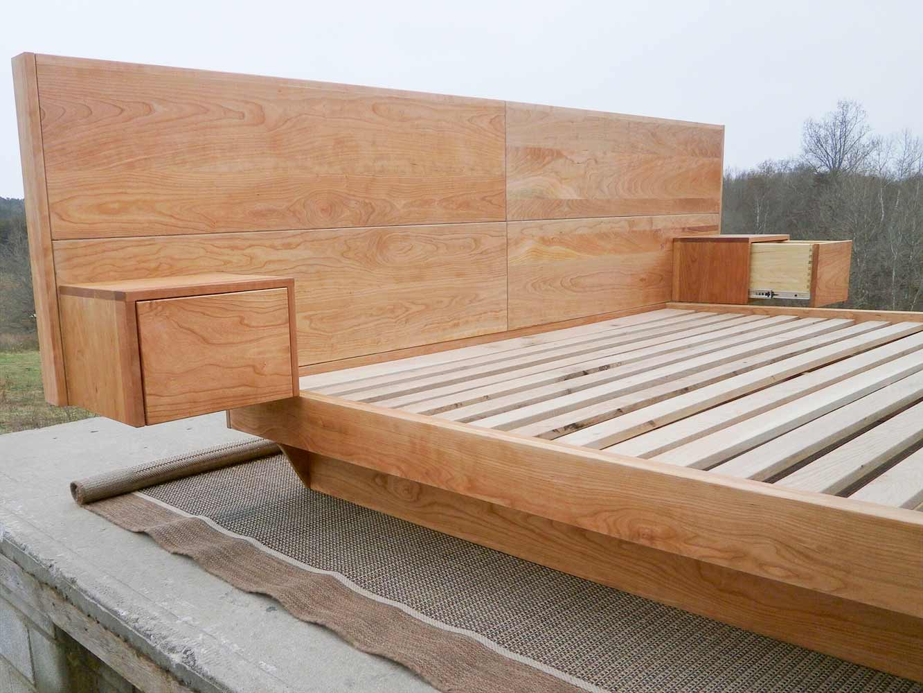 headboard of low platform bed with wide headboard attached tables and angled base frame