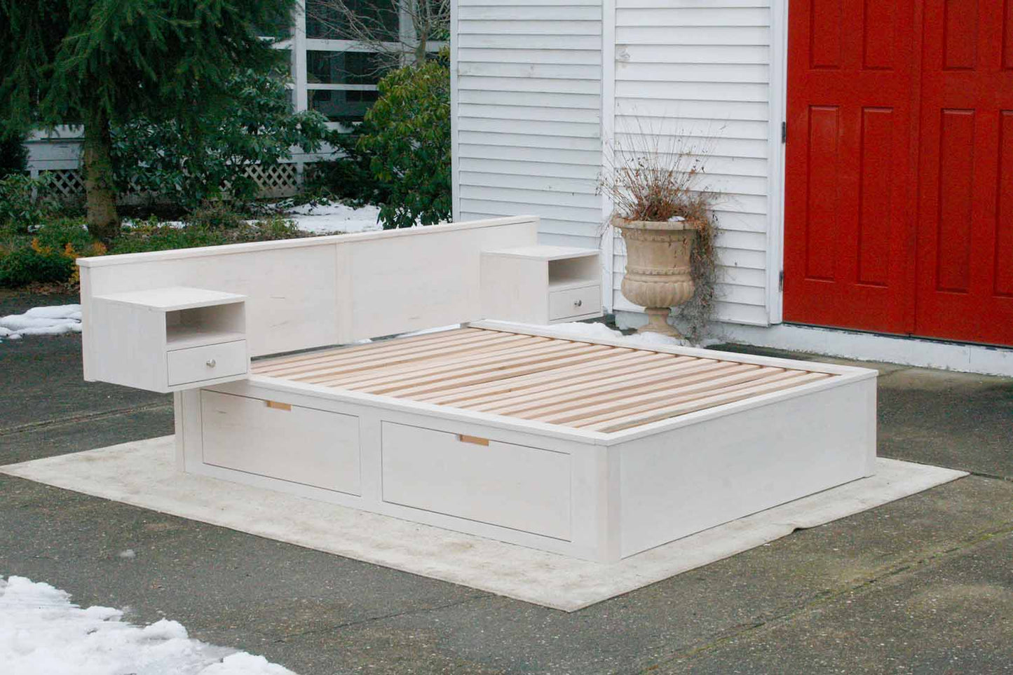 platform bed with 4 drawers wide headboard and built in side tables angled view