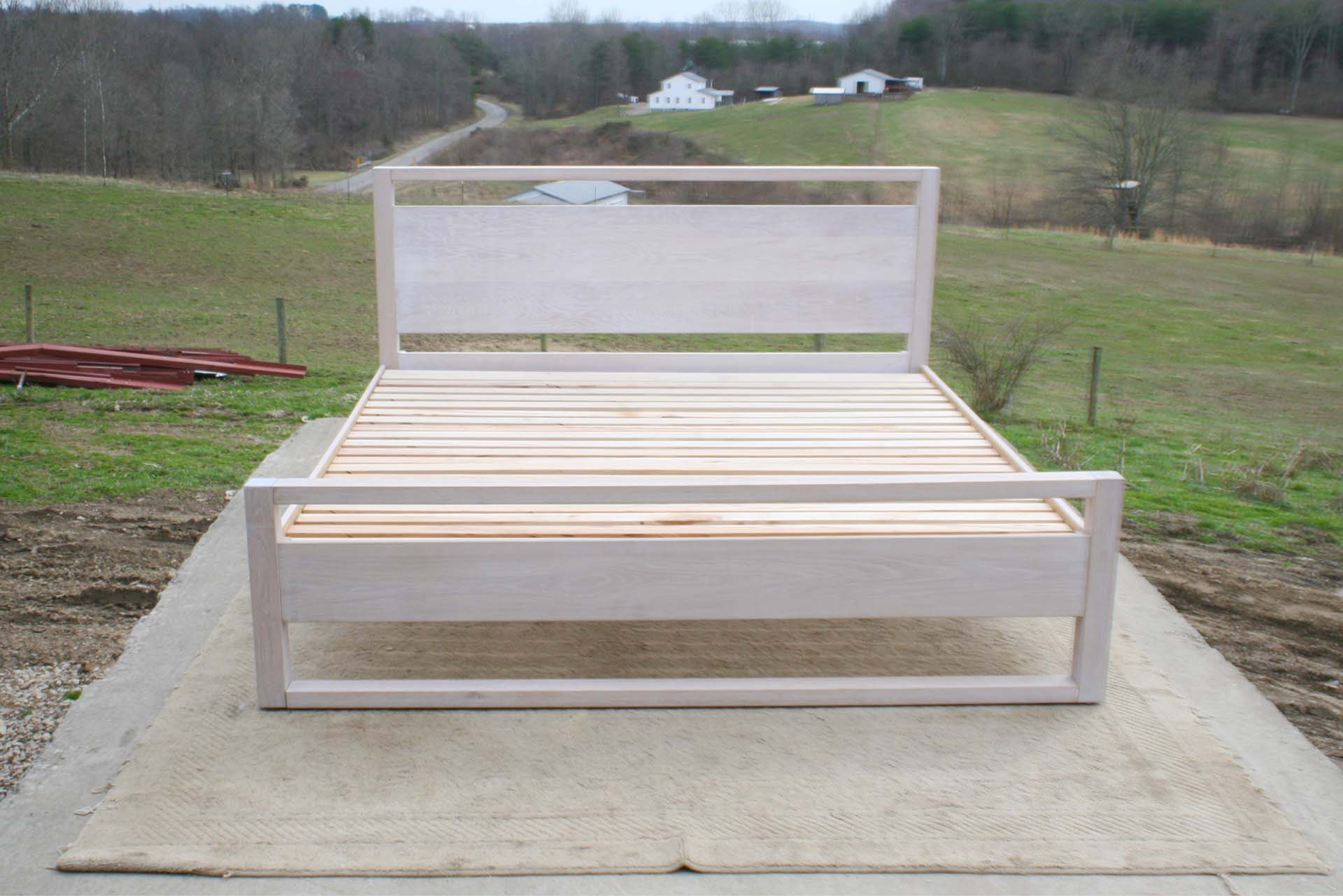 platform bed with a rail above the head board and rails at floor front view