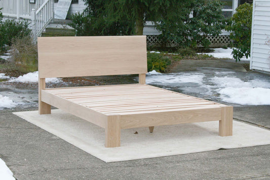 sturdy platform bed with angled headboard and wide thick posts angled side view
