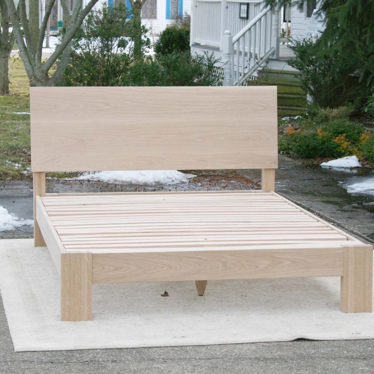 platform bed with angled headboard and wide thick posts front view