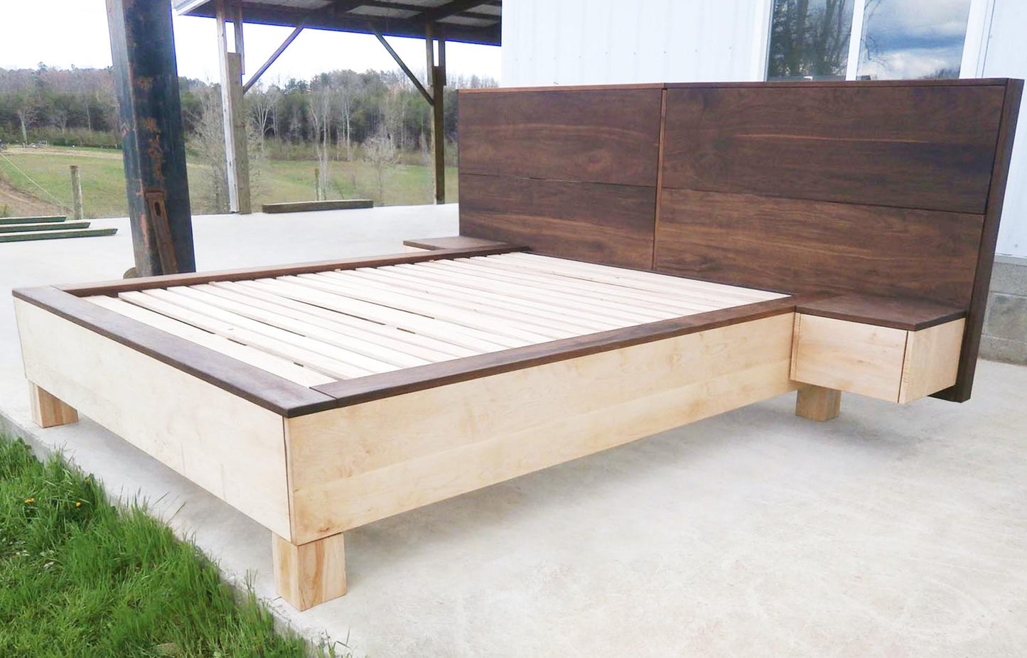 side angled view platform bed with large headboard and attached side tables