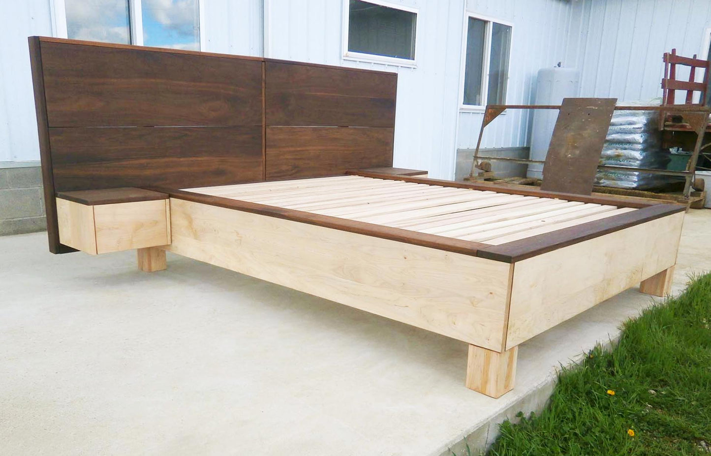 low angled view platform bed with large headboard and attached side tables