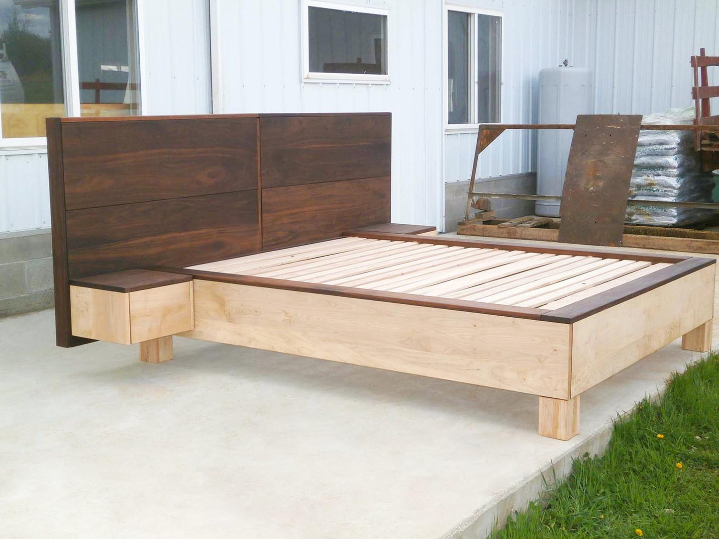 side of platform bed with large headboard and attached side tables