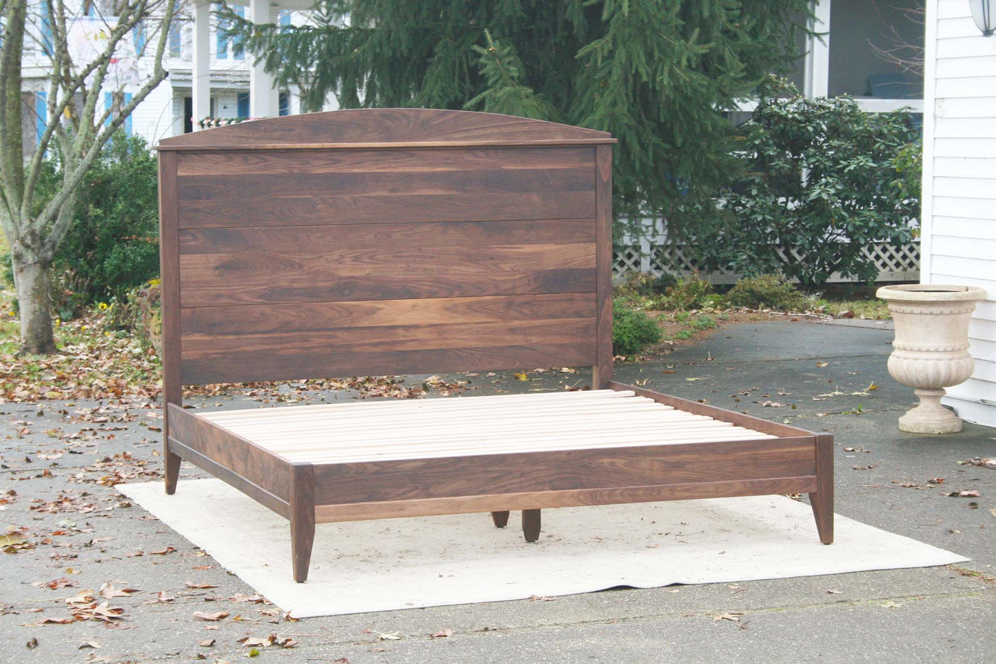 angled view platform bed with tall arched headboard