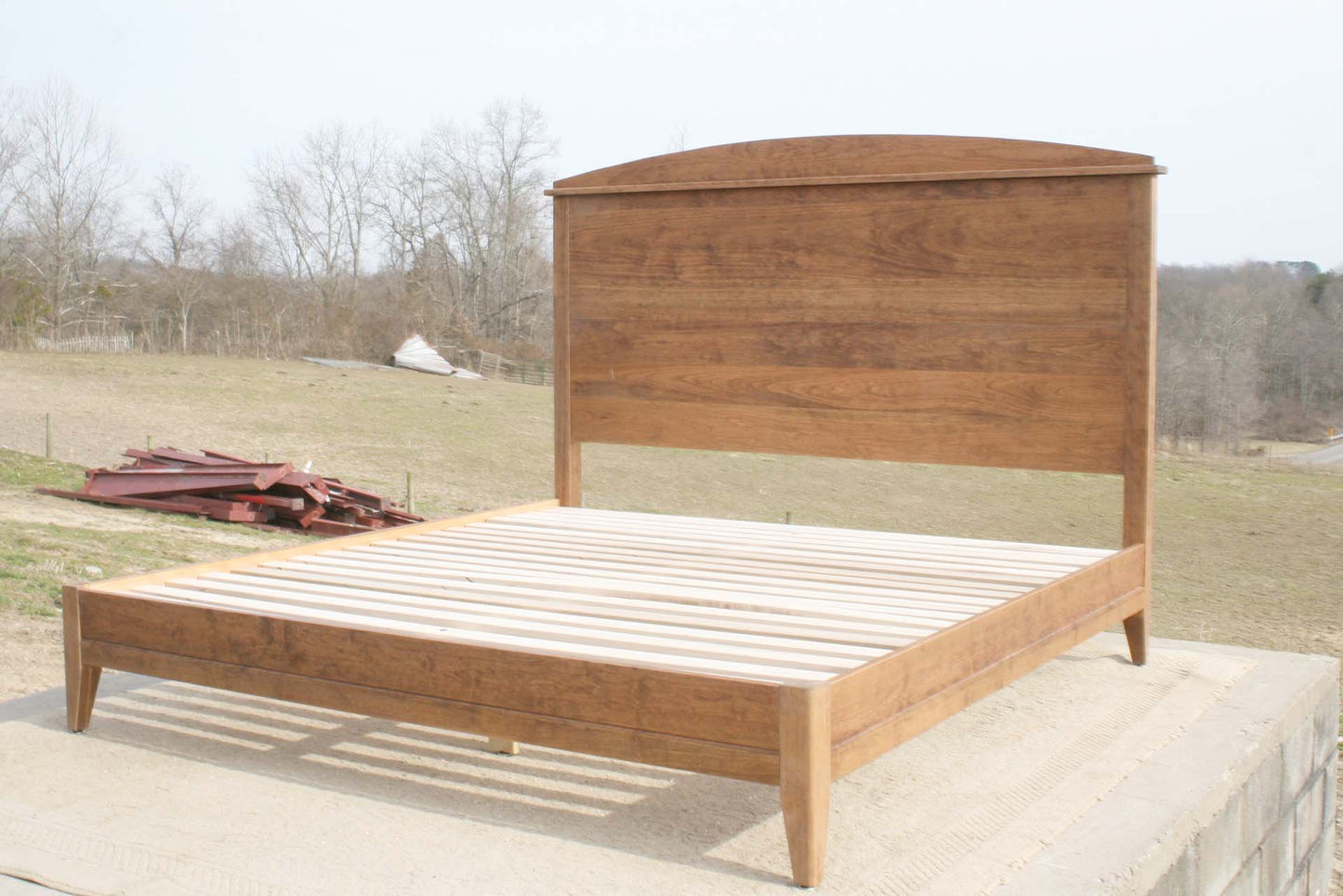 angled view platform bed with tall arched headboard