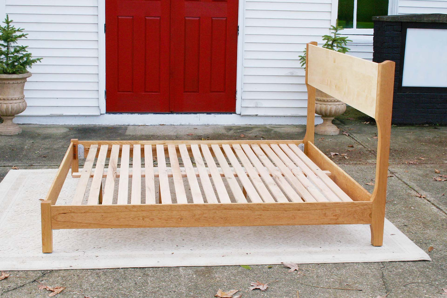 side of platform bed with tall headboard and curved posts