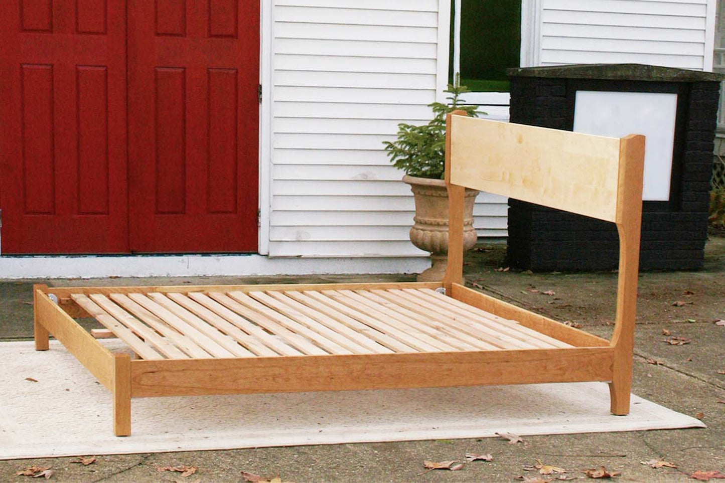 platform bed with tall headboard and curved posts side view