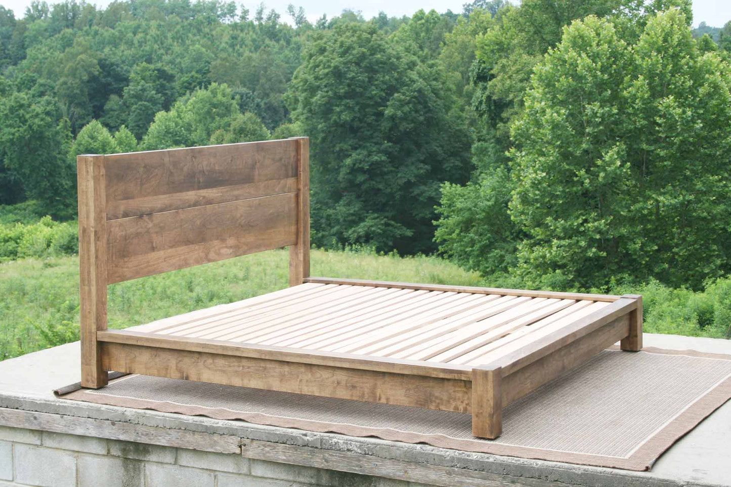 natural platform bed with thick posts and vertical headboard