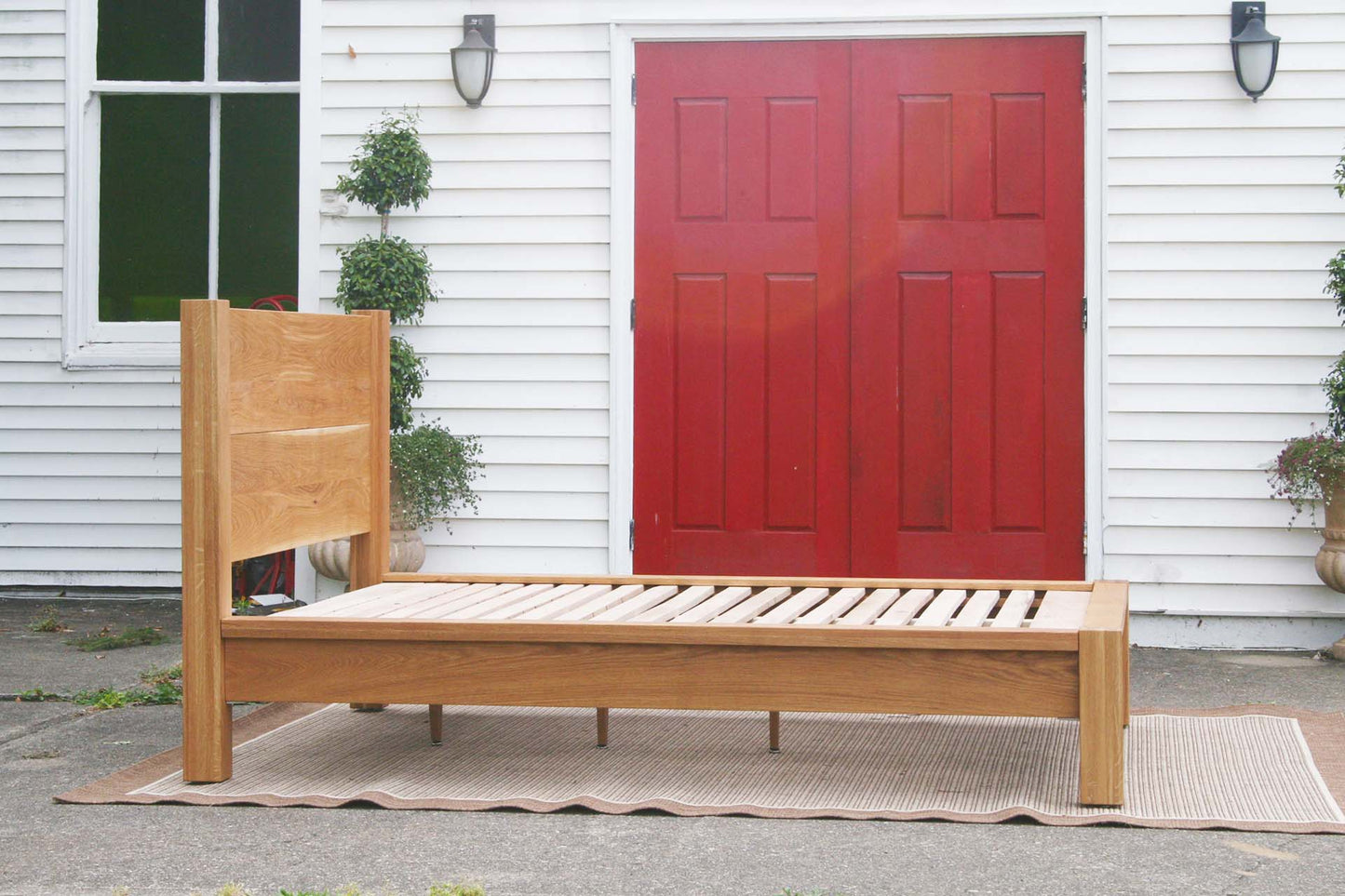 side view natural platform bed with thick posts and vertical headboard