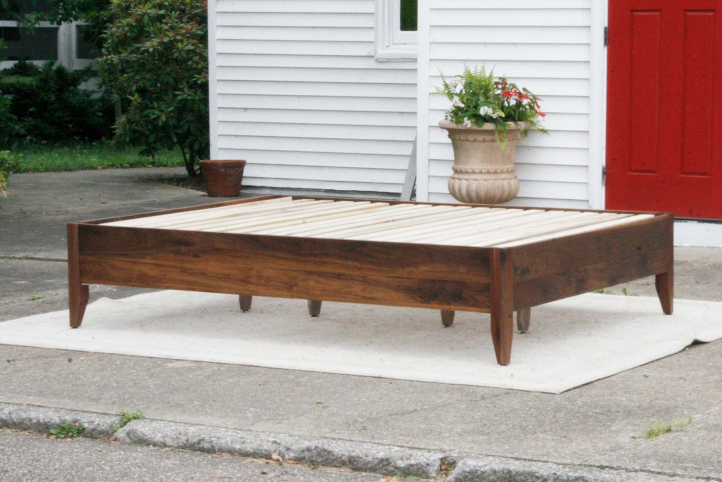 side angled view walnut storage bed with 6 drawers and angled headboard