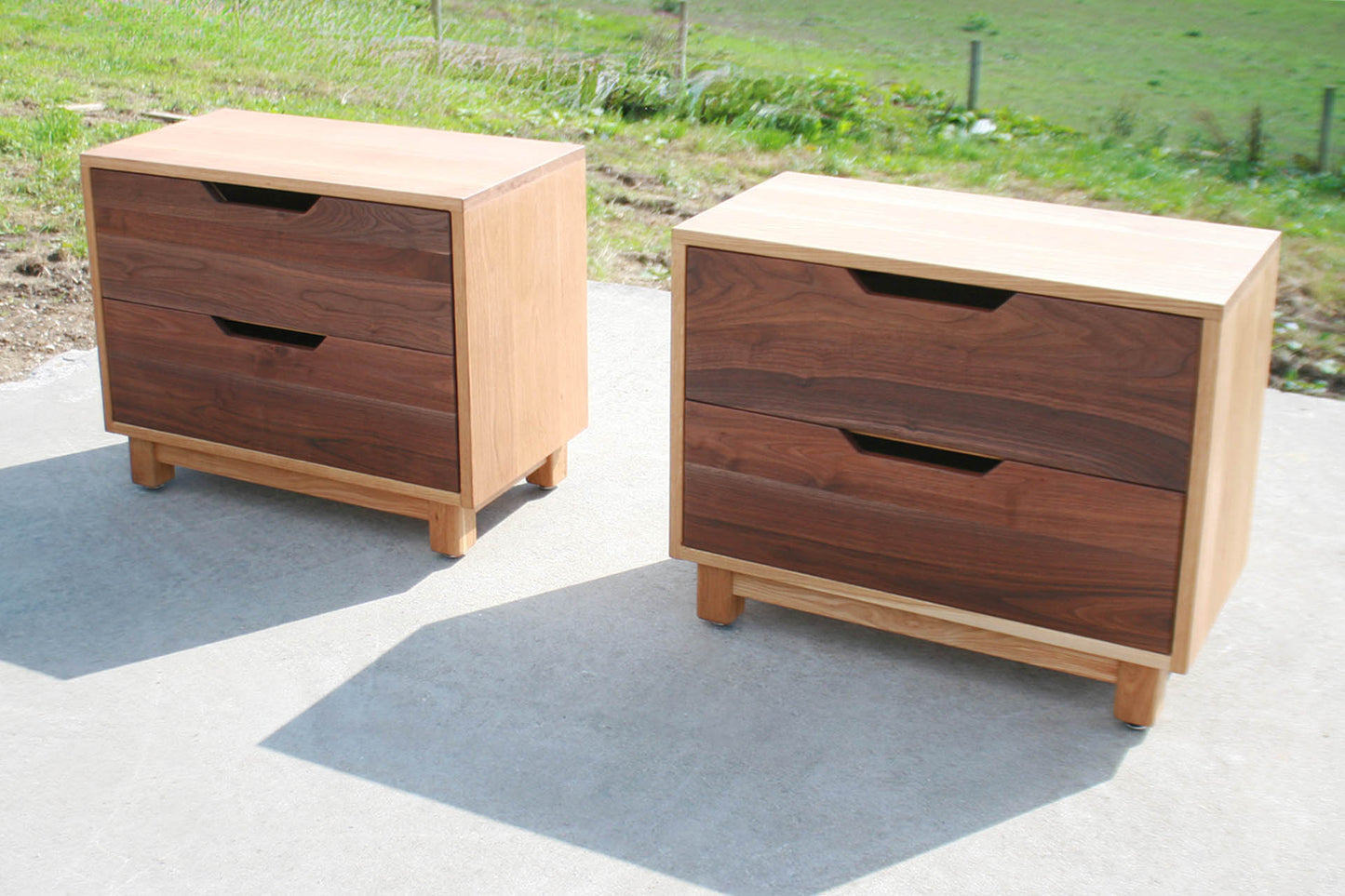 Bedside cabinet with slanted cut pulls angled front view
