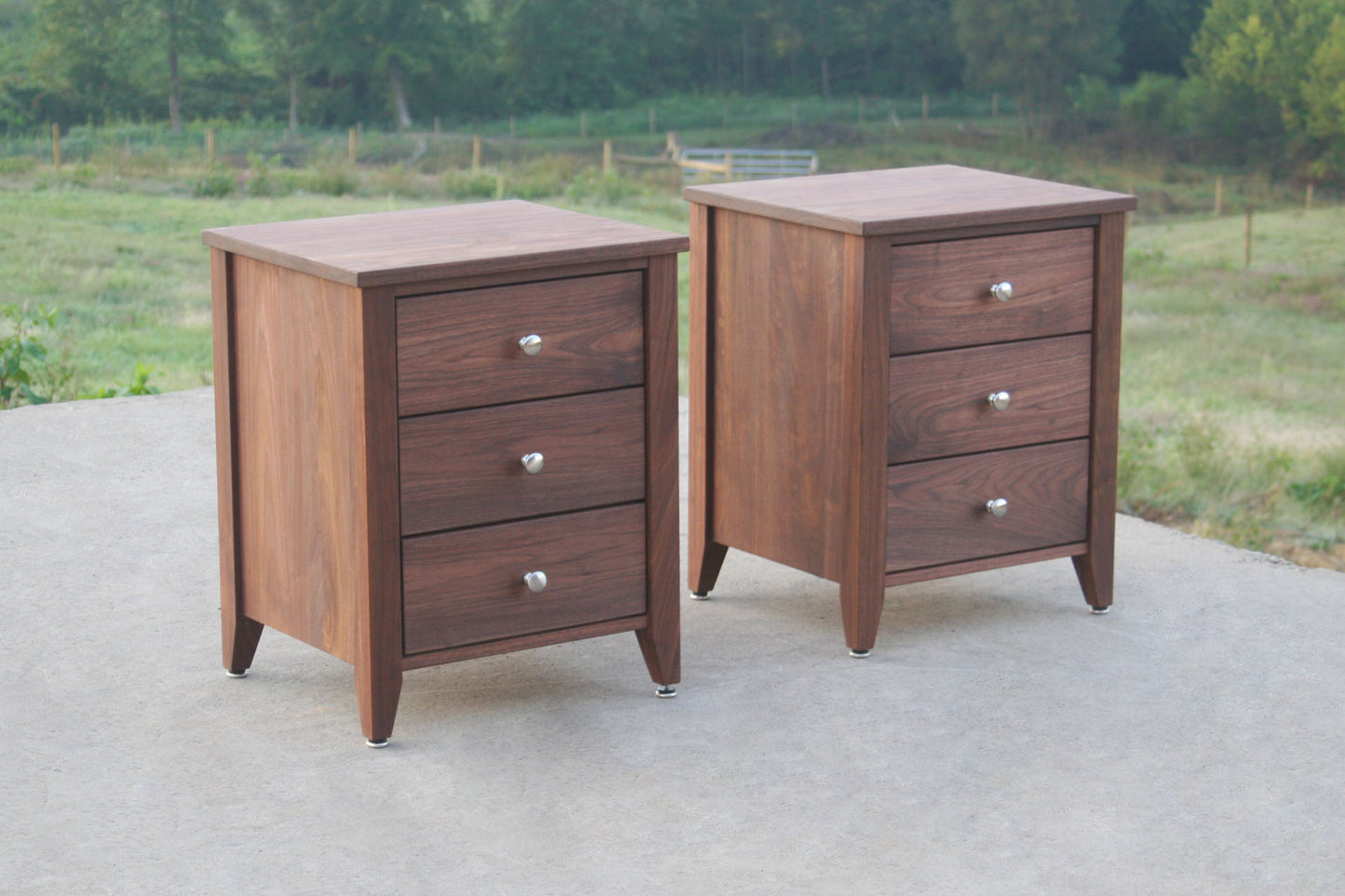 angled view night stands in solid hardwood with three drawers
