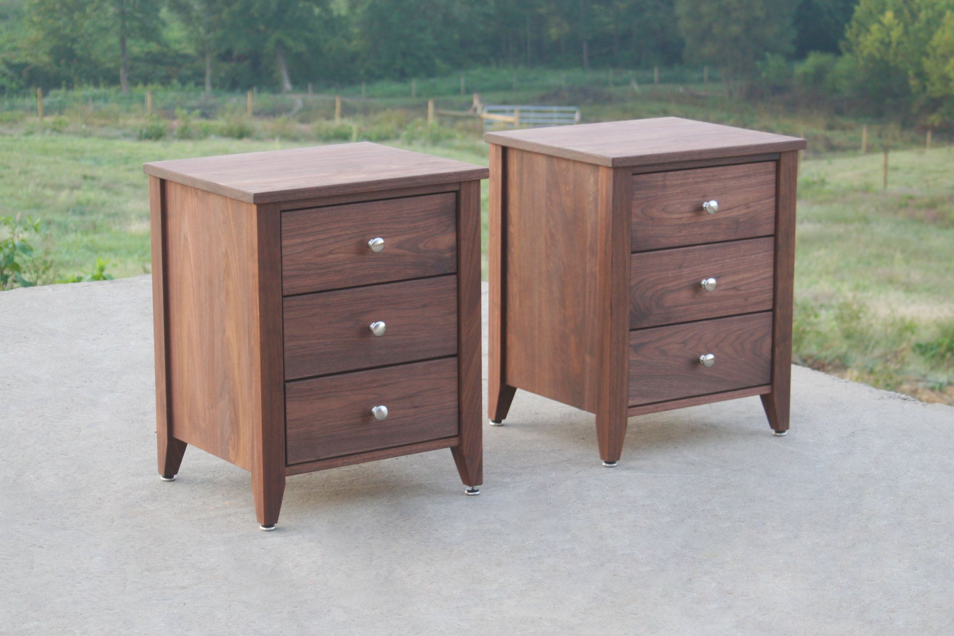 angled view night stands in solid hardwood with three drawers